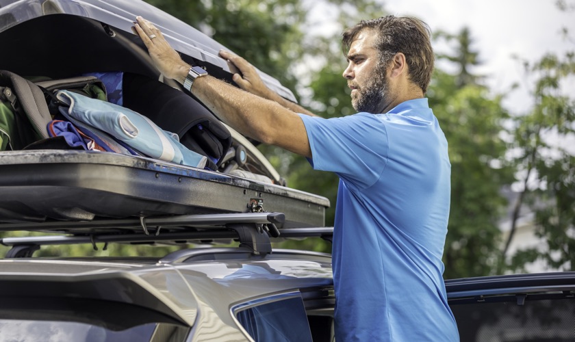 Car roof box being loaded by driver