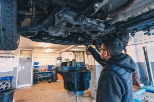 Mechanic performing under car inspection at Mr Tyre Derby