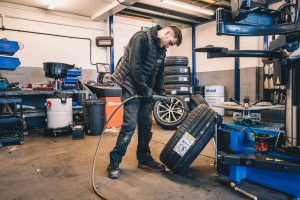 Mechanic preparing tyre for tyre change.