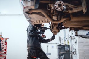 Mechanic performing checking car wheel.