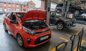 Red car with hood open being worked on at Mr Tyre Rochdale.